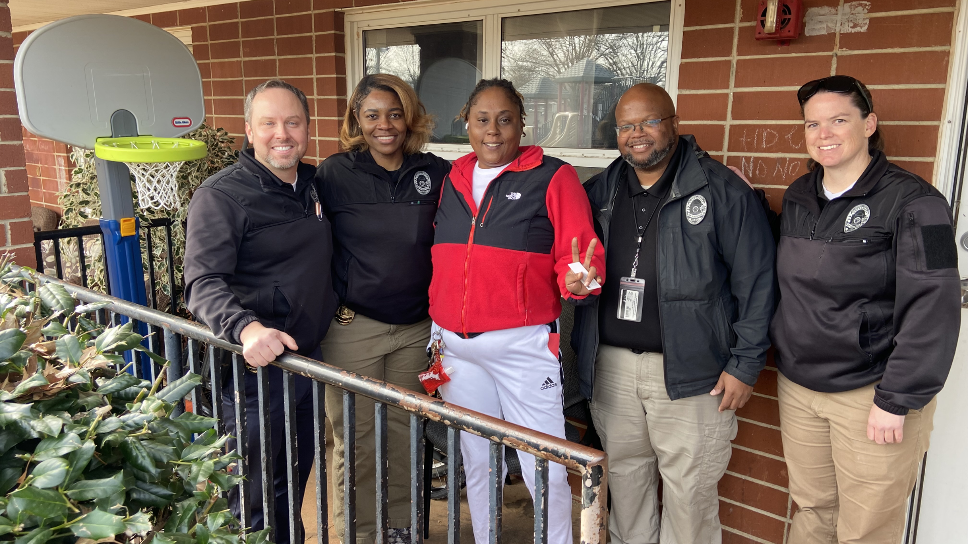 UGA Police Department personnel with Athens resident Ashley* (center) during the 2023 F&A Holiday Outreach Initiative
